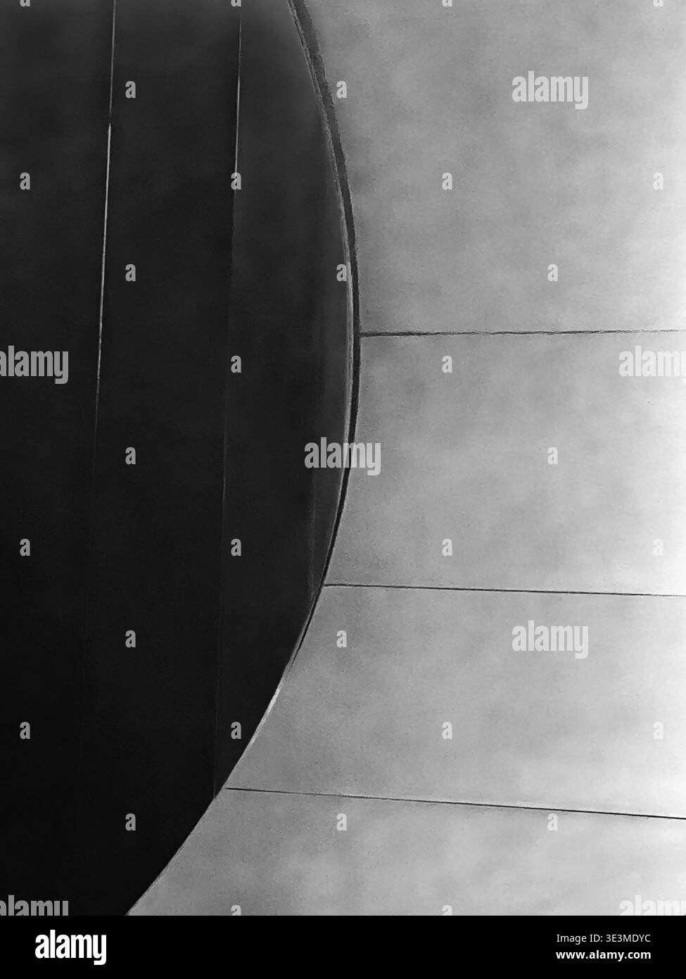 Un absrract architectural montrant un arc simple qui est créé à partir de la lumière focalisée sur la courbe d'un escalier. Banque D'Images