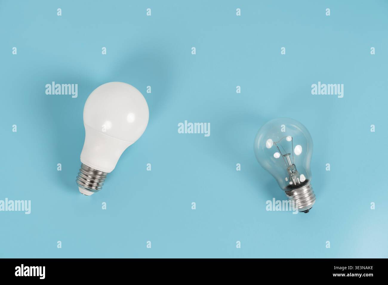 Vue de dessus des ampoules LED et incandescentes sur fond bleu, symbolisant l'économie d'énergie, remplacement de l'éclairage, comparaison de l'efficacité, électrique domestique Banque D'Images