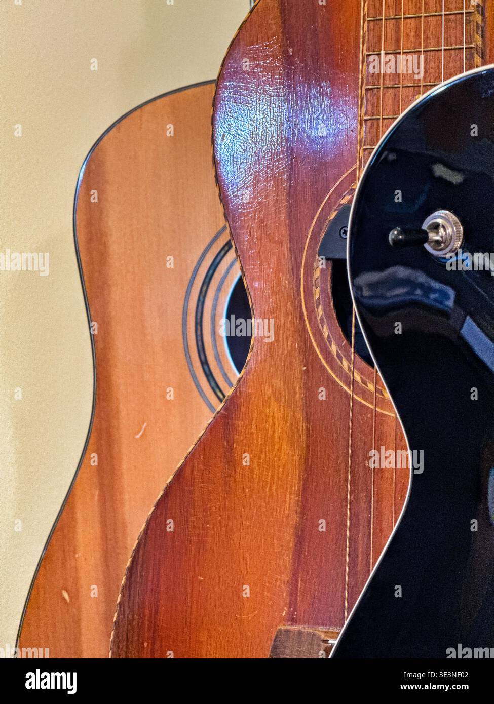 Trois guitares usagées exposées dans un magasin soulignent les formes courbes des instruments de musique. Banque D'Images