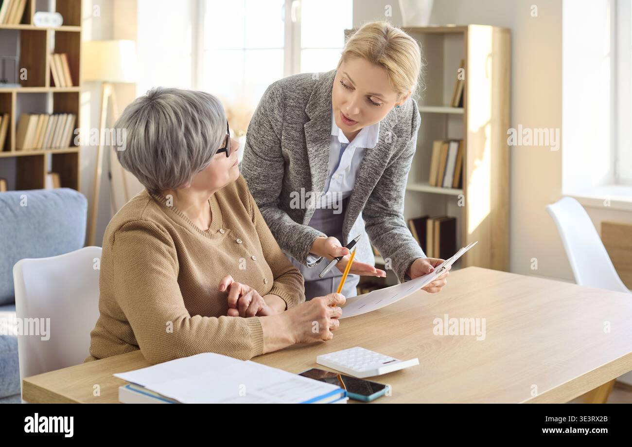 Femme senior rencontrant un conseiller financier à la maison pour la paperasse et la planification Banque D'Images