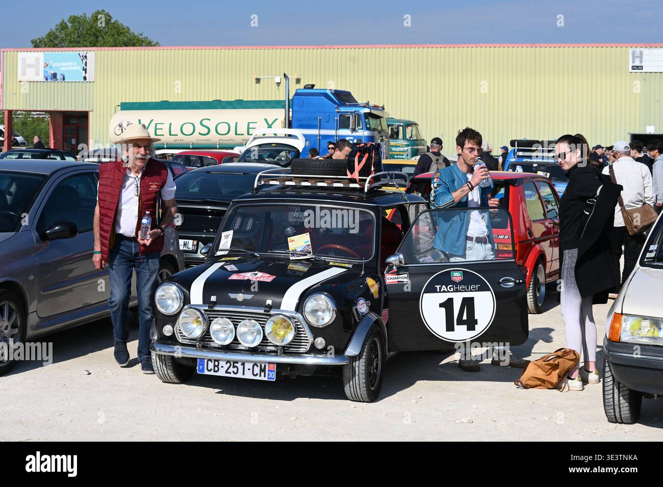 Visiteurs à l'exposition de voitures anciennes ou au salon de l'automobile et Vintage Mini Cooper aux couleurs de Racng ou voiture de rallye au salon de l'automobile Motor passion Avignon France Banque D'Images