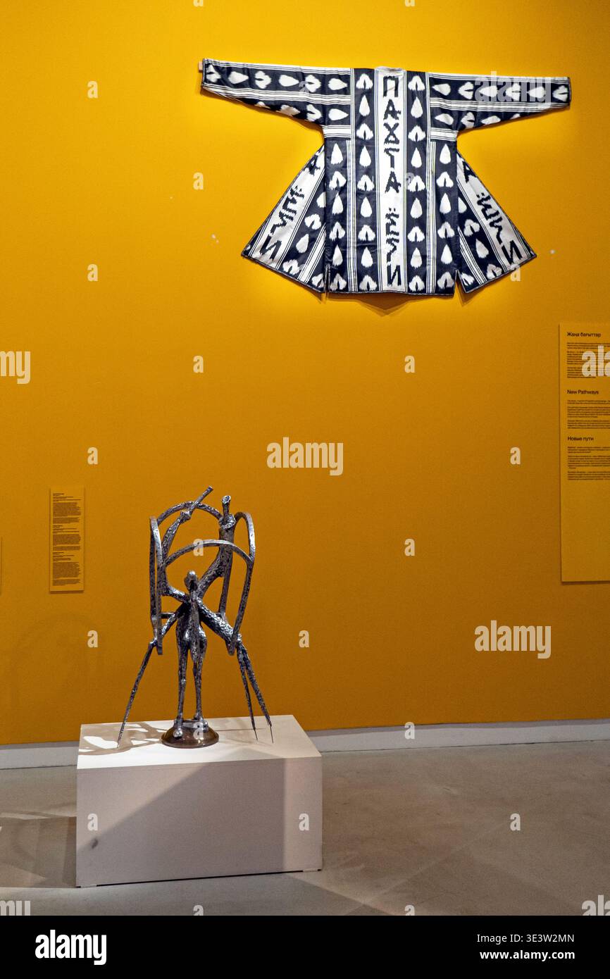Collage textile chapan en denim contemporain avec texte kazakh et sculpture en métal abstrait à la galerie du Musée des Arts d'Almaty Banque D'Images