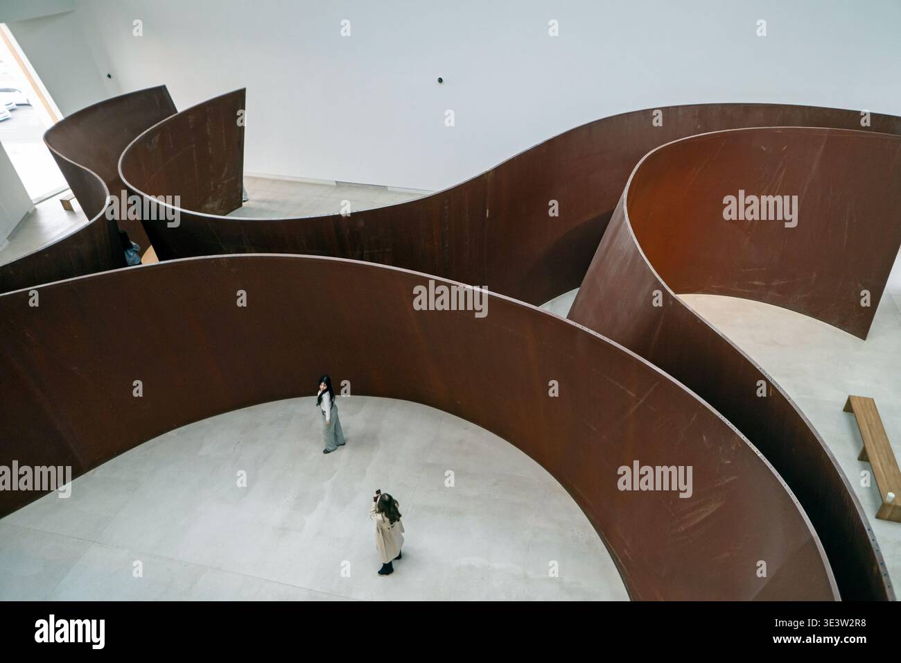Vue aérienne de Richard Serra Crossroads sculpture en acier altérée avec deux visiteurs à Almaty Banque D'Images