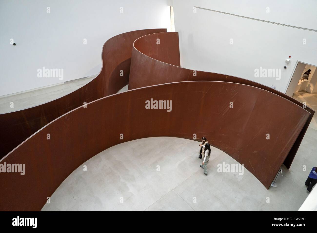 Richard Serra Crossroads sculpture en acier avec un visiteur solitaire marchant à l'intérieur des murs courbes à Almaty Banque D'Images