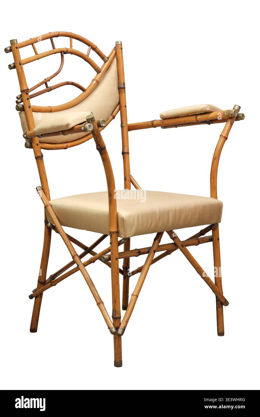 Cette charmante chaise en bambou dispose d'un design unique et de coussins crème doux, le rendant parfait pour la détente dans un espace de vie serein ou corne ensoleillée Banque D'Images