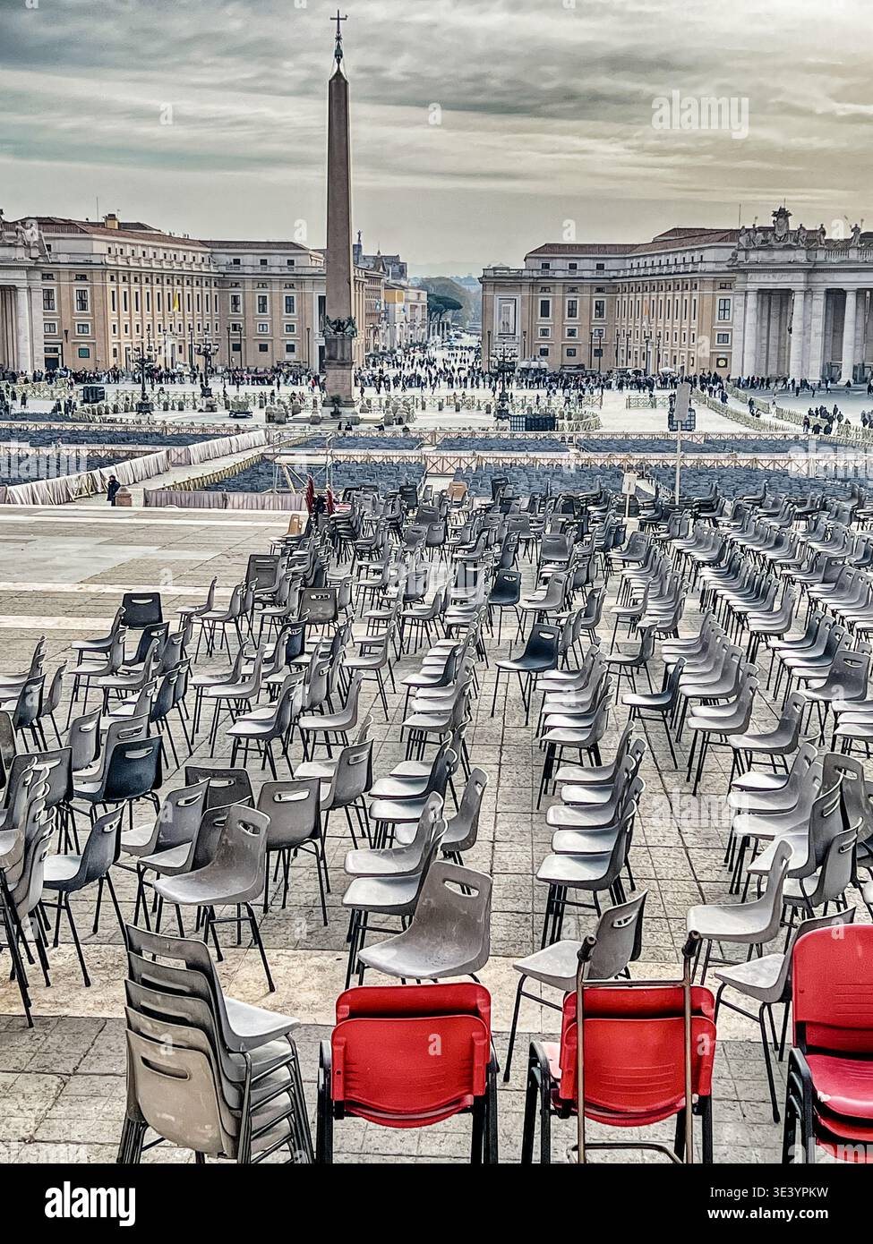 Quelques chaises rouges se dressent devant des centaines de chaises noires sur la piazza à l'extérieur de la basilique de Pierre à Rome. Banque D'Images