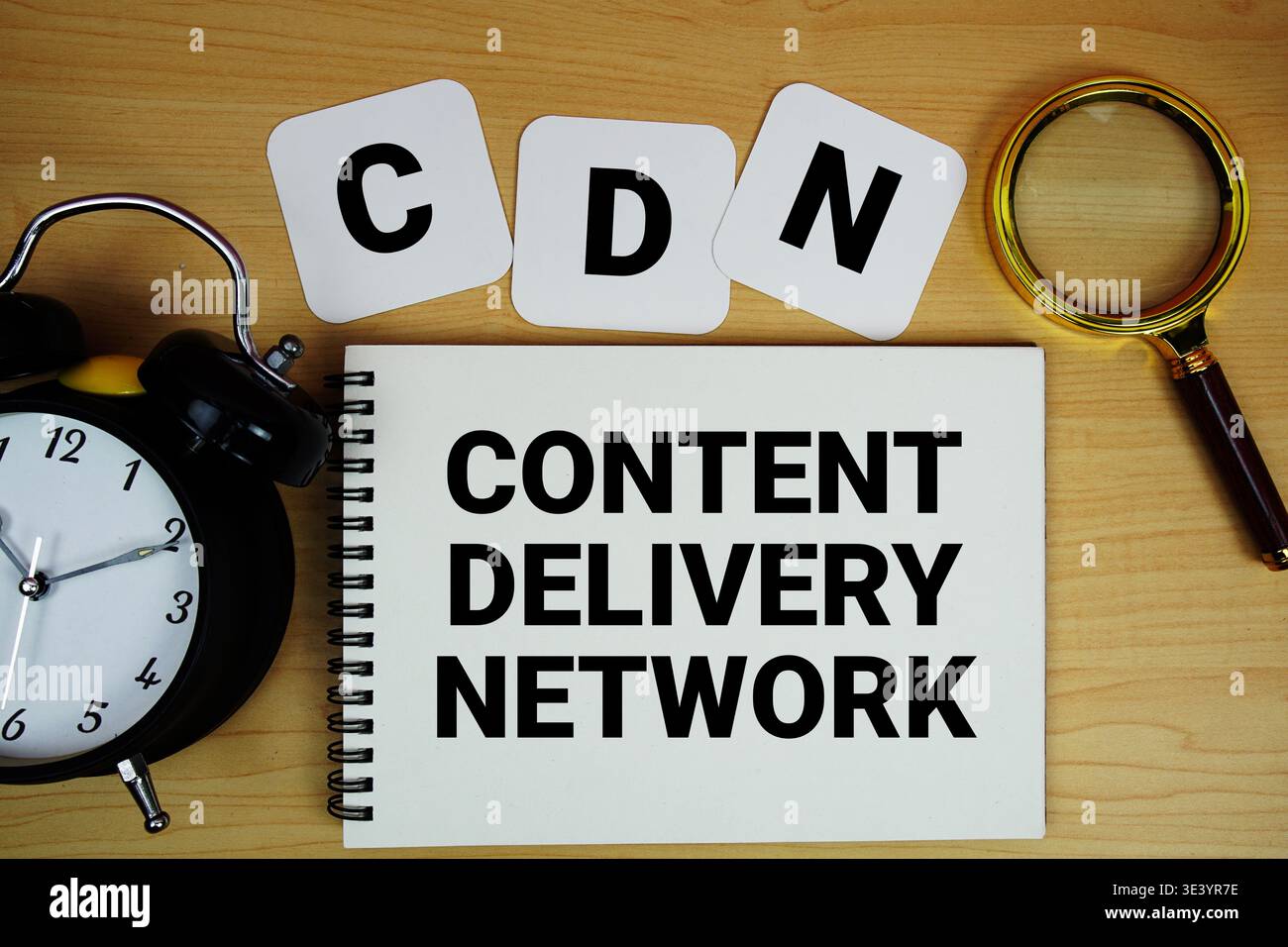 CDN Content Delivery Network texte écrit sur bloc-notes avec loupe et réveil sur fond de bois Banque D'Images