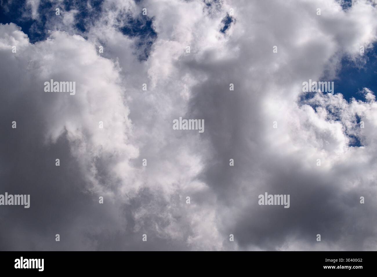 Ciel spectaculaire rempli de nuages blancs moelleux sur bleu profond. Les nuages sombres de tempête font allusion à un temps changeant. Parfait pour les arrière-plans montrant la tension, n Banque D'Images