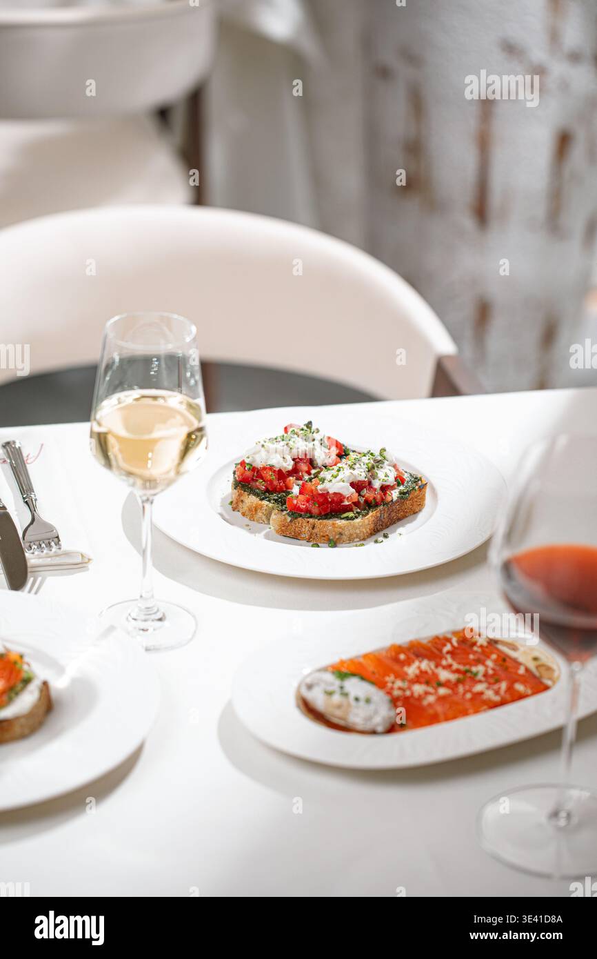 Table de restaurant élégante avec hors-d'œuvre et vin Banque D'Images