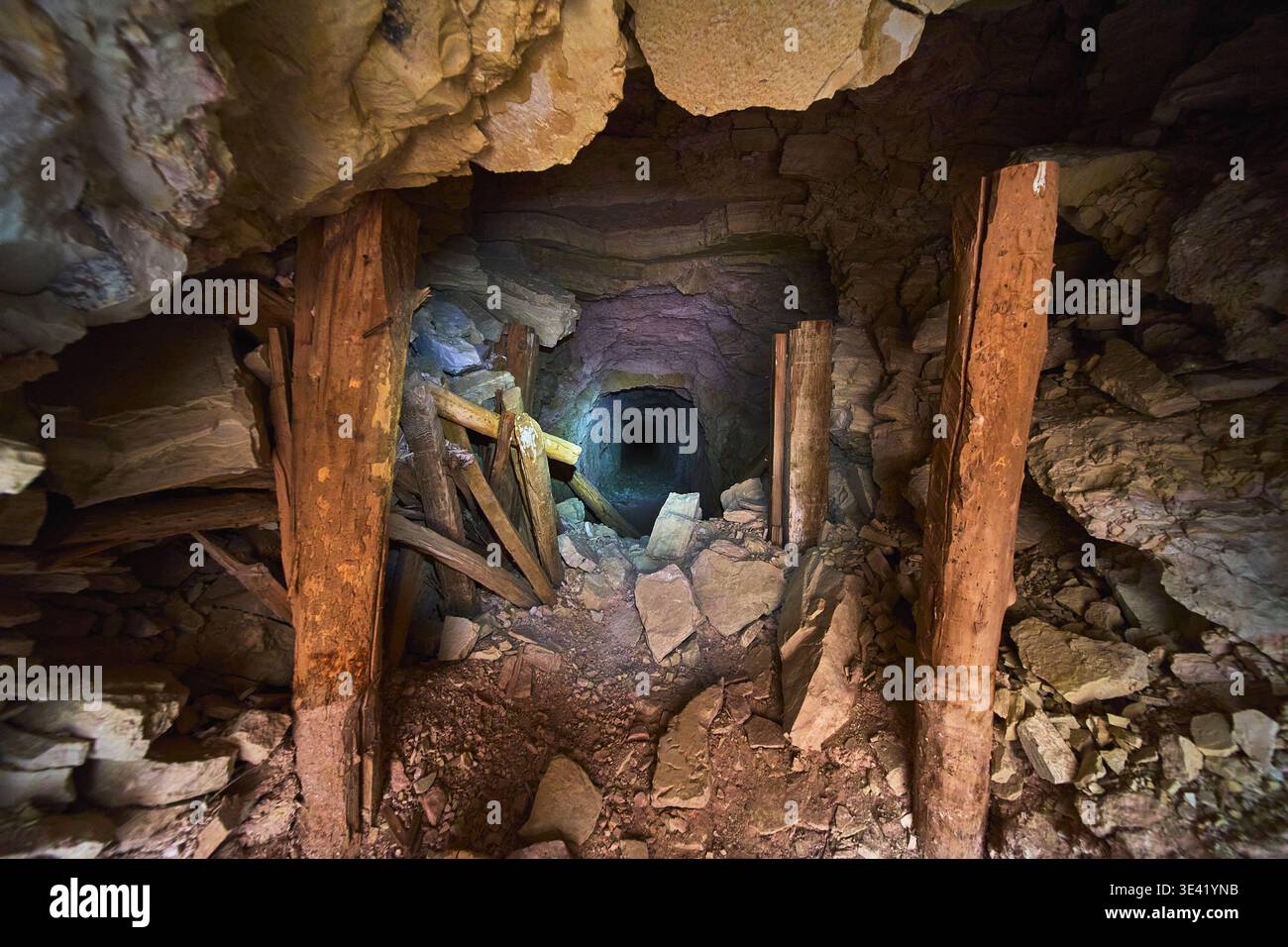Tunnel de mine abandonné avec supports en bois et débris rocheux intérieur Banque D'Images