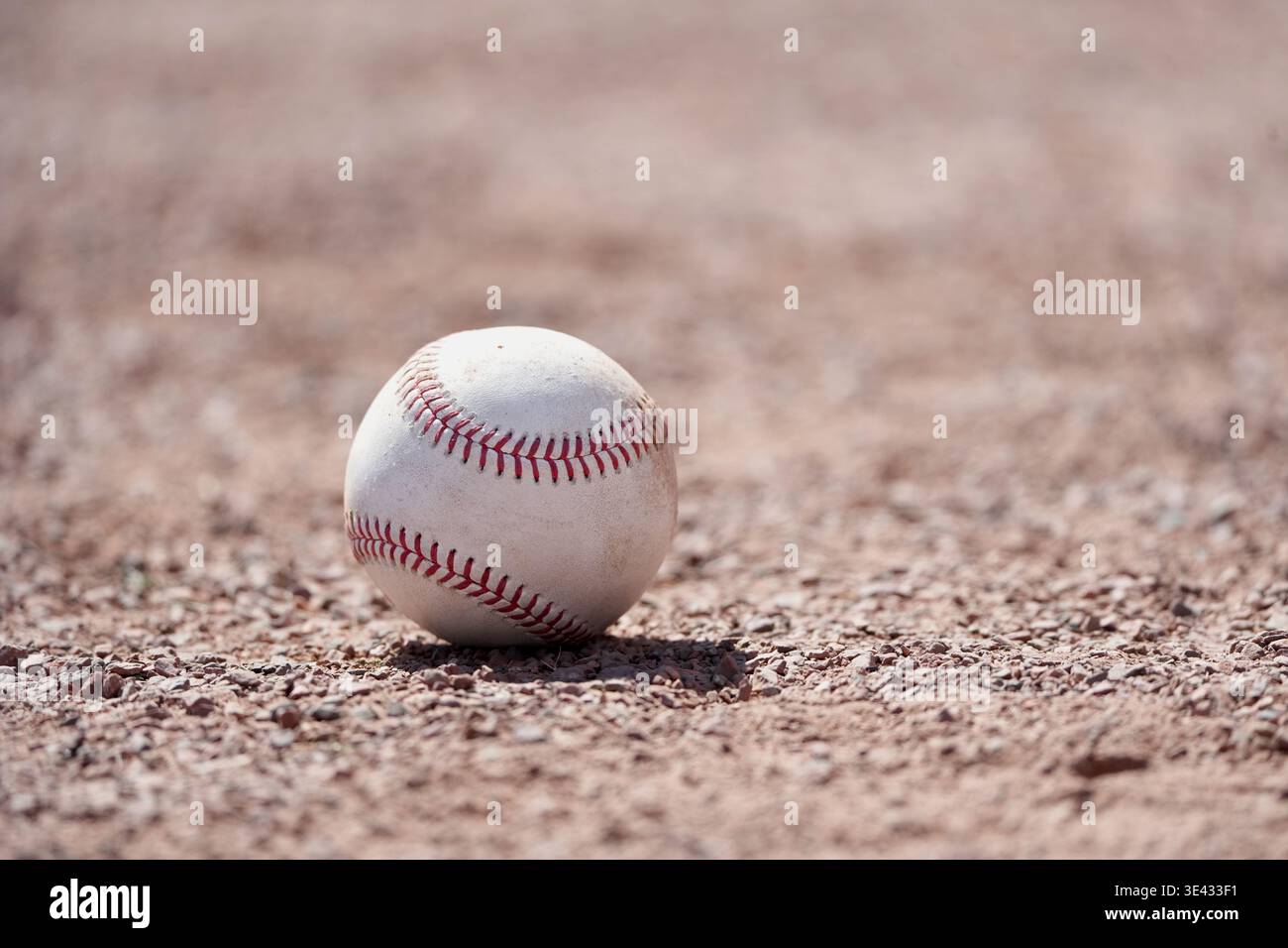 Une balle de baseball sur la terre intérieure d'un diamant de baseball. Banque D'Images