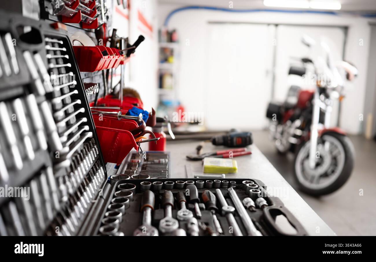Instruments et outils de mécanicien sur Un établi avec Une moto dans Un garage Banque D'Images