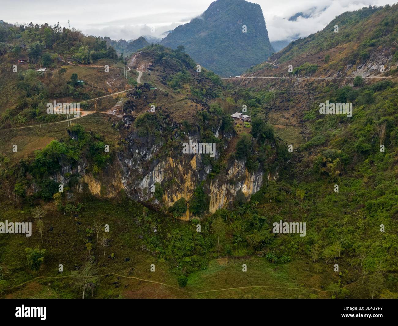 Près de me Pja Pass, Vietnam – 13 janvier 2024 : une vue de drone montre une route de montagne sinueuse au-dessus de falaises rocheuses et une vallée rurale dans le nord du Vietnam. Banque D'Images