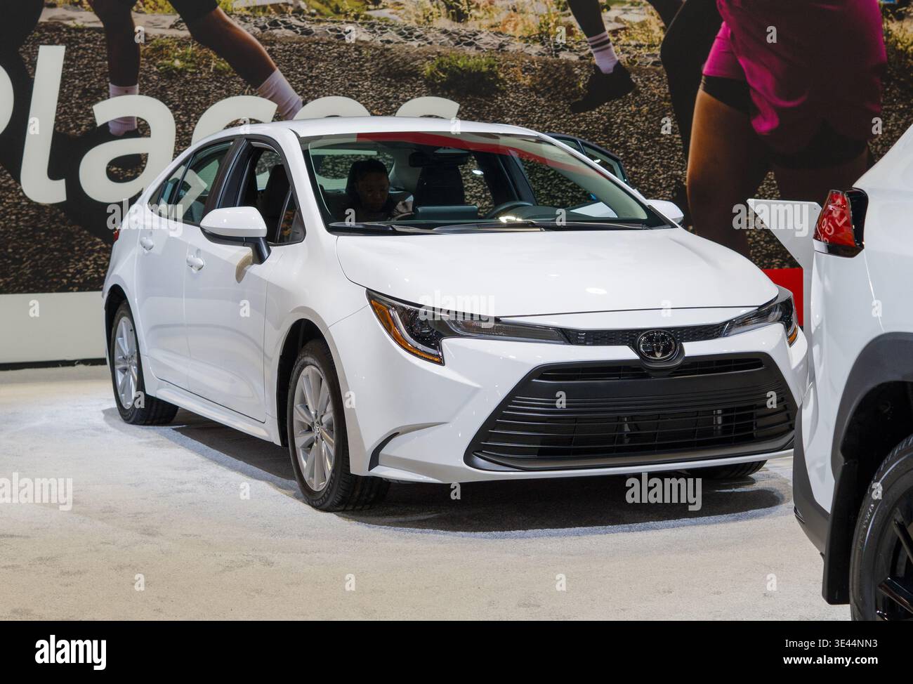 Berline Toyota Corolla blanche présentée lors d'un salon de l'auto intérieur. La berline compacte est présentée aux visiteurs lors d'un salon automobile. Banque D'Images