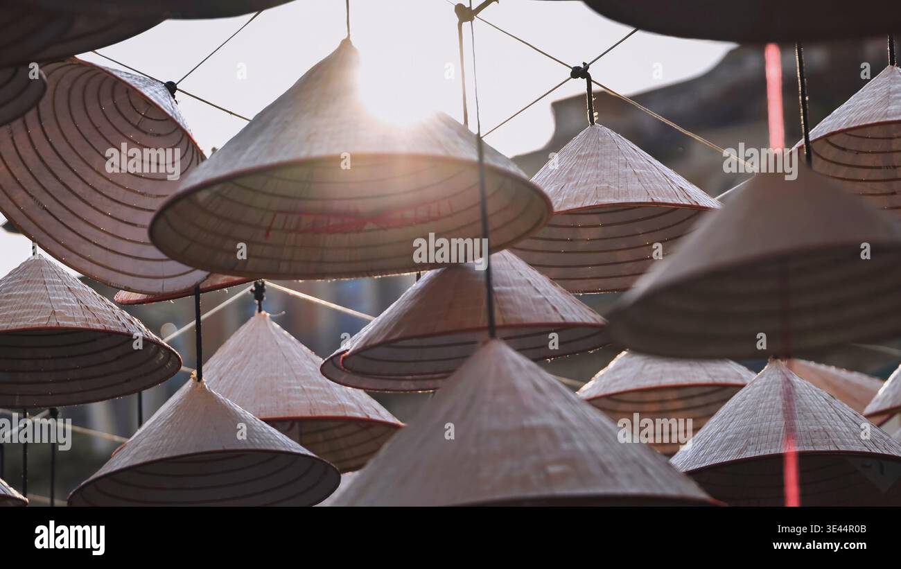 Chapeaux coniques asiatiques traditionnels suspendus à l'extérieur contre un soleil éclatant Banque D'Images