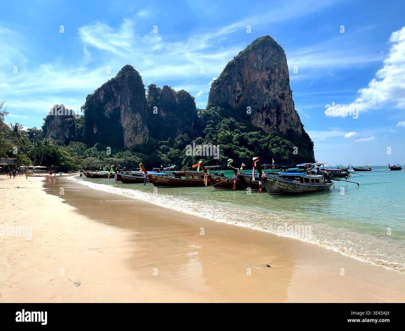 Bateaux traditionnels Longtail amarrés sur la plage de Railay avec des falaises de calcaire Krabi Thaïlande - Image de stock capturée avec un smartphone