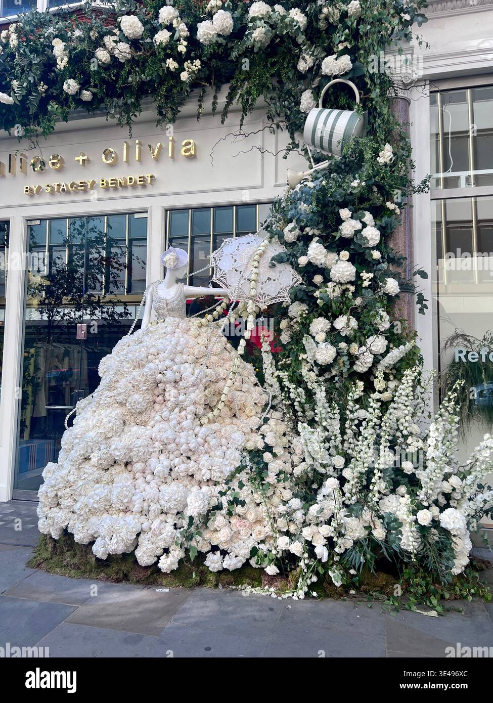 Exposition de fleurs de Chelsea avec une robe de mariée faite de roses blanches et de pivoines. Arrangement de fleurs blanches tout le long de la façade du magasin. Banque D'Images