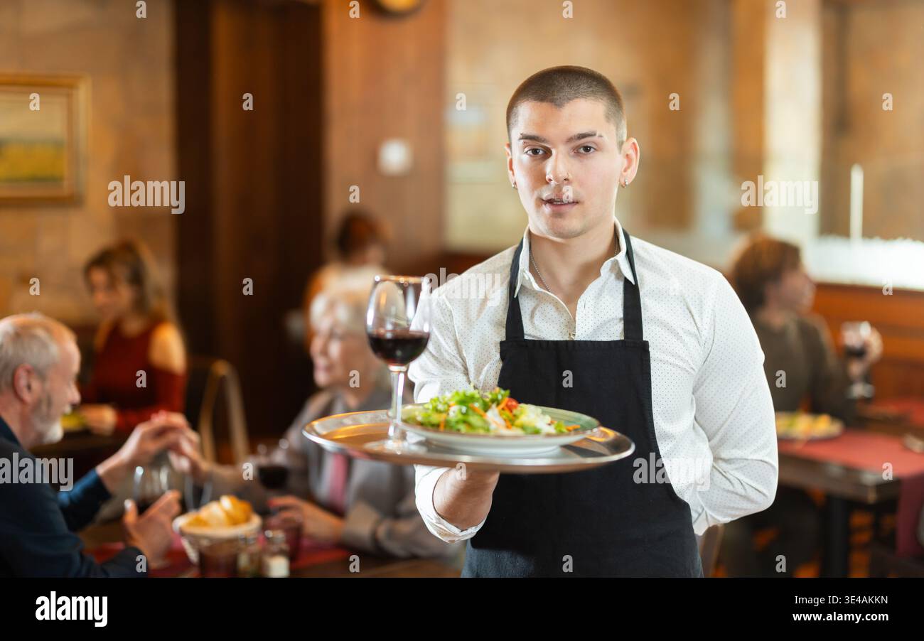Guy serveur avec plateau dans le hall du café Banque D'Images