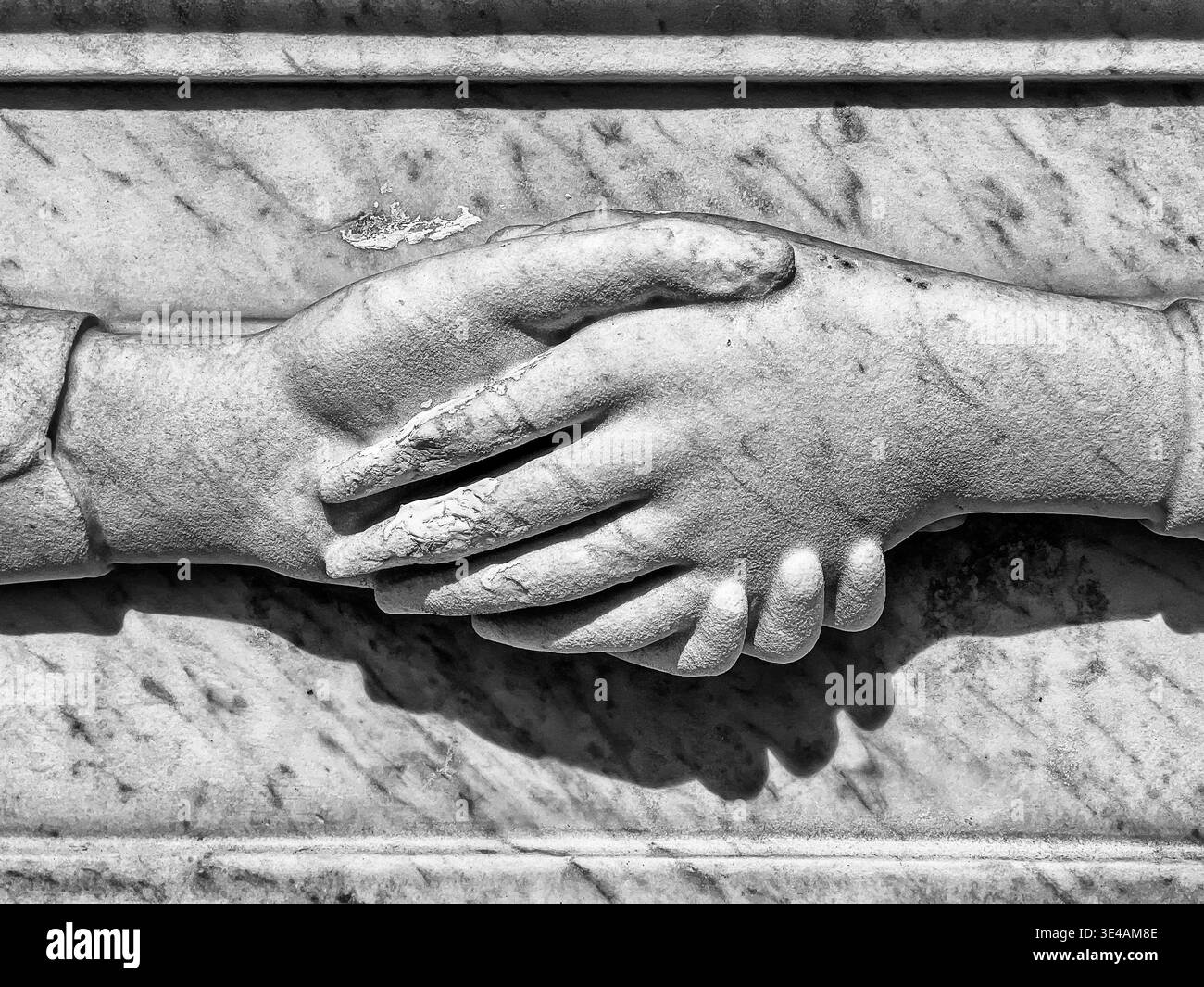 Deux mains, sculptées dans la pierre, sont toujours tenues sur une pierre tombale du cimetière du Père Lachaise à Paris. Banque D'Images