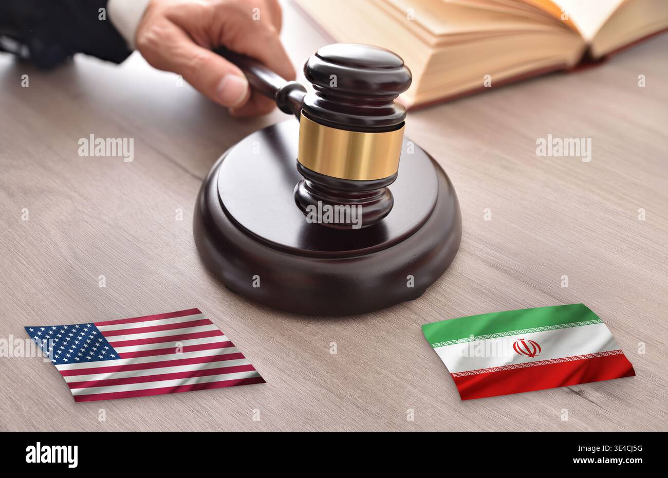 Gros plan du marteau d’un juge au-dessus des drapeaux américain et iranien sur un bureau, symbolisant un différend juridique, une tension géopolitique et la résolution de conflits internationaux. Banque D'Images