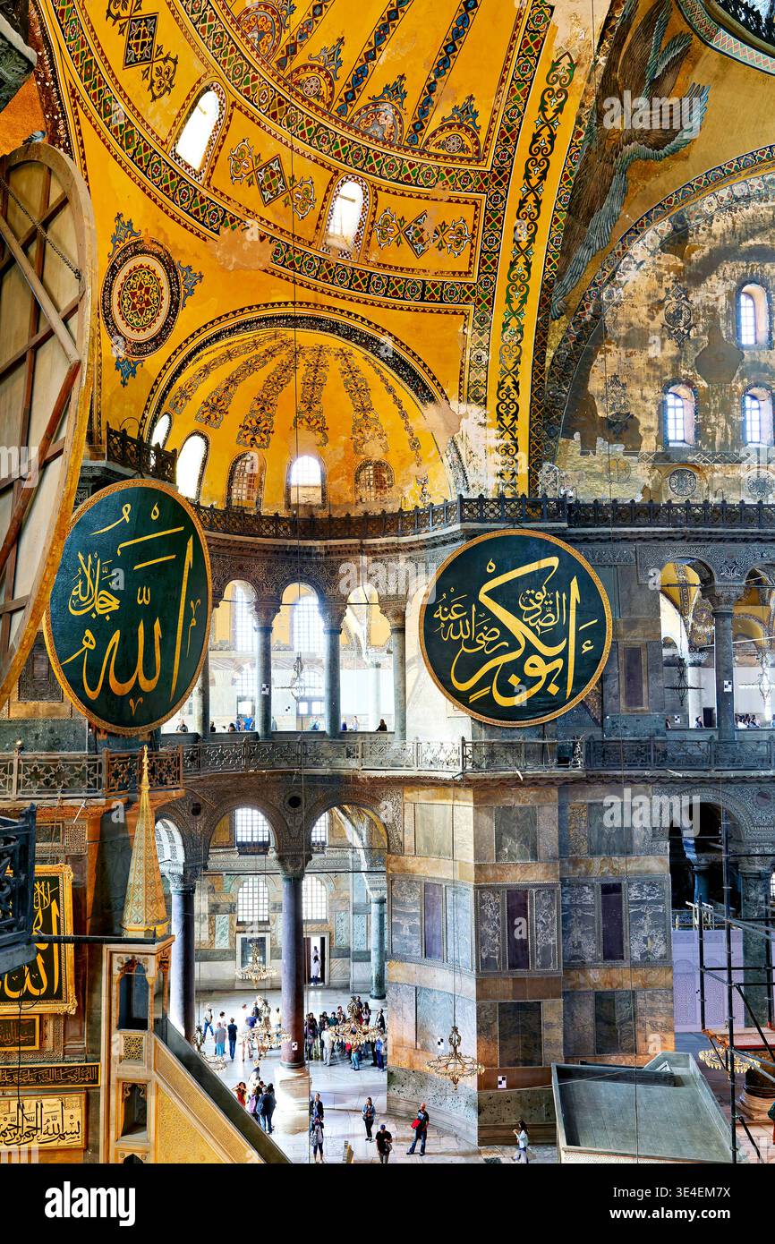 Les visiteurs explorent la Grande Mosquée Sainte-Sophie à Istanbul. La grande architecture présente de grands dômes et des motifs ornés. Banque D'Images