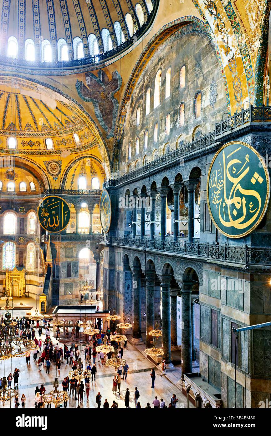 Beaucoup de gens marchent à travers la Grande Mosquée Sainte-Sophie à Istanbul. Ils admirent l'architecture et voient les grandes décorations sur les murs. Banque D'Images