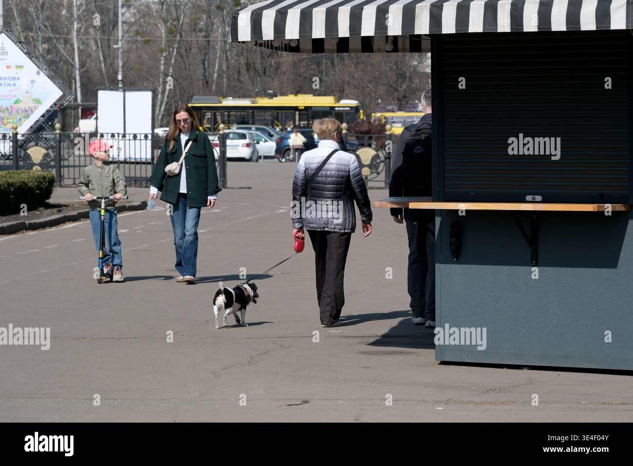 Les gens apprécient une place animée de la ville avec un chien, des scooters et des vibrations joyeuses. Ukraine, Kiev, Expocenter of Ukraine, 27 mars 2026 Banque D'Images