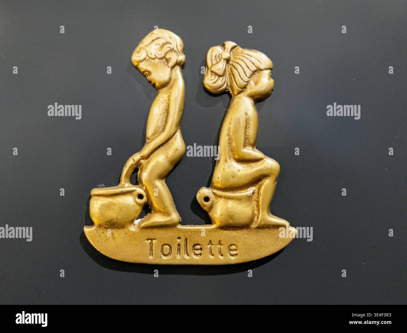Un panneau humoristique sur une porte de toilettes montre un garçon et une fille en train de faire leur truc. Banque D'Images