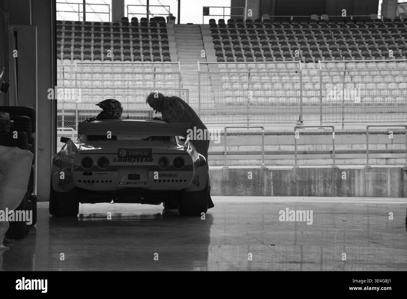 Pilote de course nettoie sa Chevrolet Corvette C3 dans la voie des stands au Red Bull Ring, Spielberg, Styrie, Autriche Banque D'Images