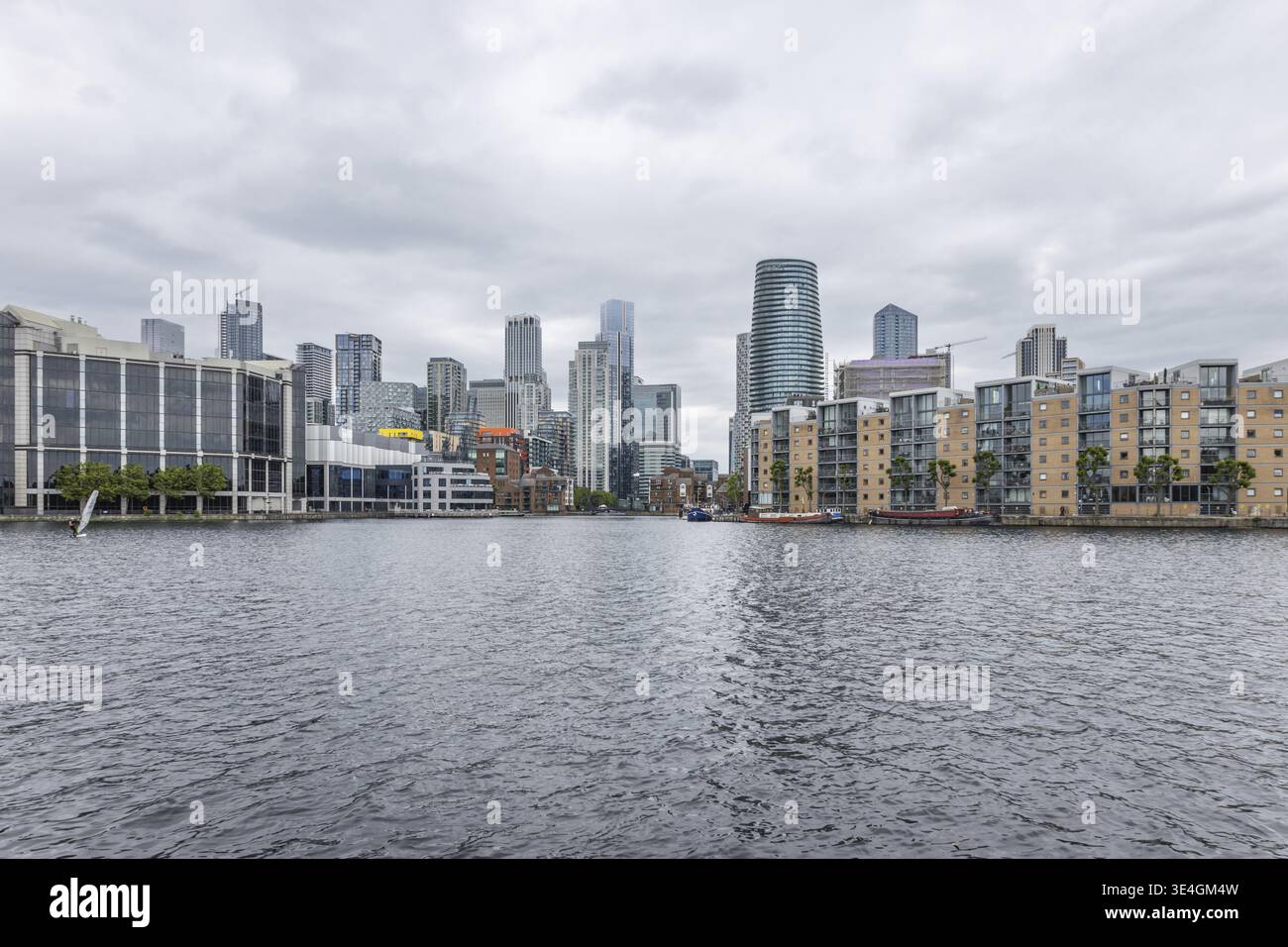 Une vue panoramique sur les gratte-ciel de London Canary Wharf et les gratte-ciel du quartier financier se reflètent dans l'eau sous un ciel couvert. Londres, Royaume-Uni, 9 Ju Banque D'Images