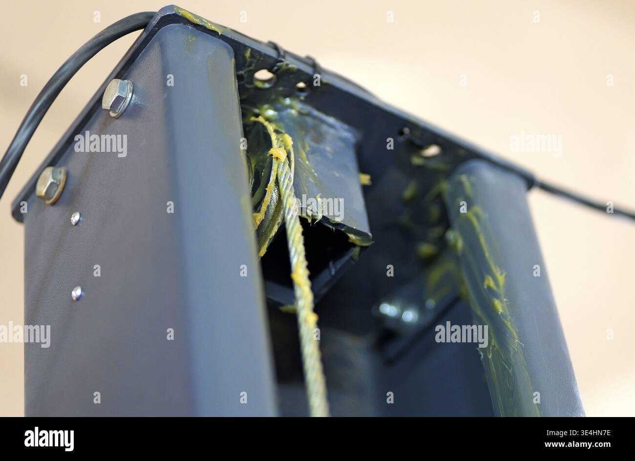 Un gros plan d'un mécanisme de levage de voiture extra-robuste montre une chaîne à feuilles lubrifiée, une poulie et un câble en acier avec des composants hydrauliques dans un kit d'atelier Banque D'Images