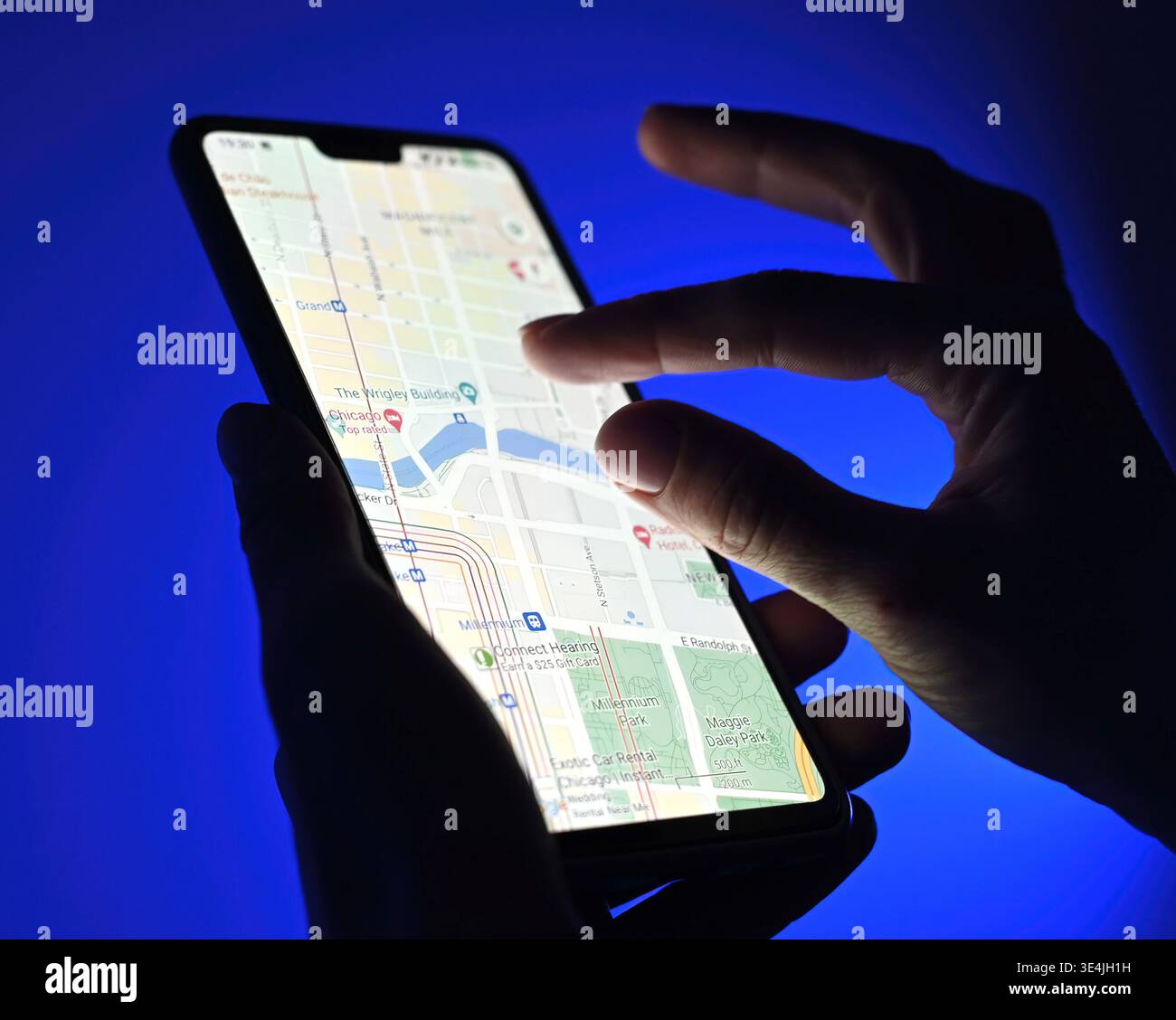 Poznan, Pologne - 13 janvier : fille utilisant l'application google Maps sur un smartphone sur fond bleu, vue rapprochée Banque D'Images