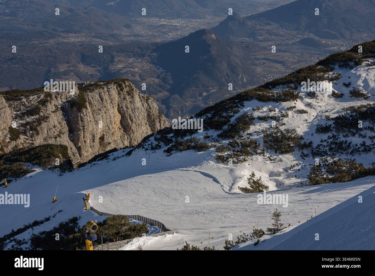 Piste de ski enneigée avec canons à neige et vue sur les montagnes alpines, paysage de station d'hiver dans les Alpes italiennes Banque D'Images