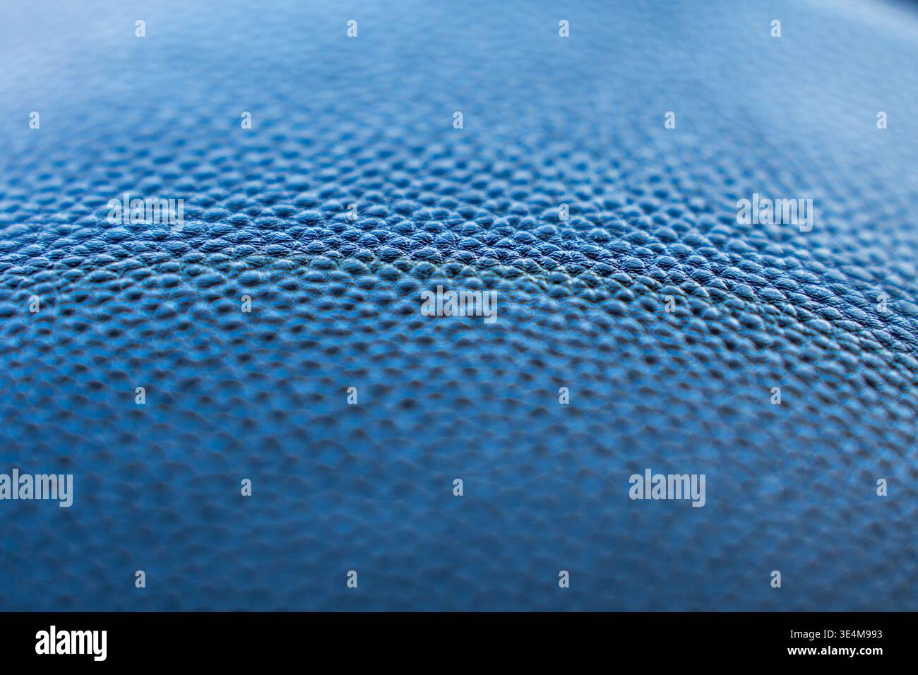 Gros plan d'une surface en cuir bleu texturé présentant son grain unique, sa profondeur de couleur et de design Banque D'Images