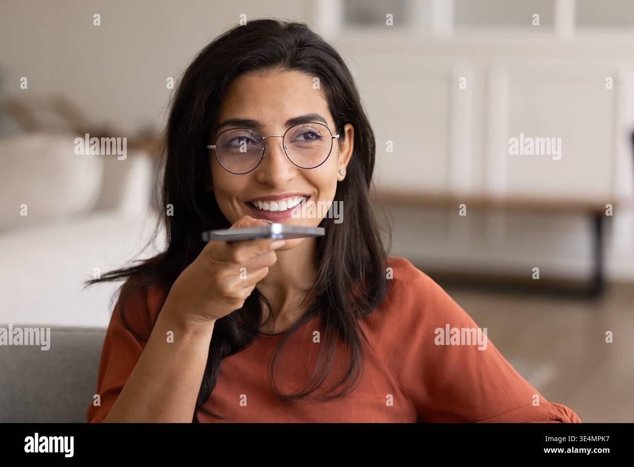 Femme tenant un smartphone, parlant sur le haut-parleur ou en utilisant l'assistant vocal Banque D'Images