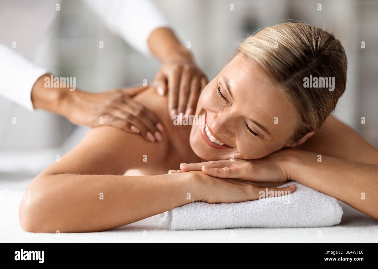 Belle femme d'âge moyen profitant d'une séance de massage dans le centre de bien-être Banque D'Images