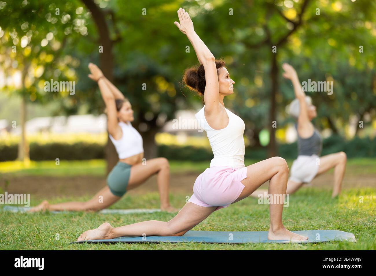 Femme adulte faisant du yoga dans le parc Banque D'Images