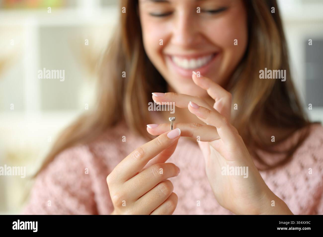Gros plan portrait d'une fiancée heureuse regardant la bague de fiançailles sur son doigt à la maison Banque D'Images