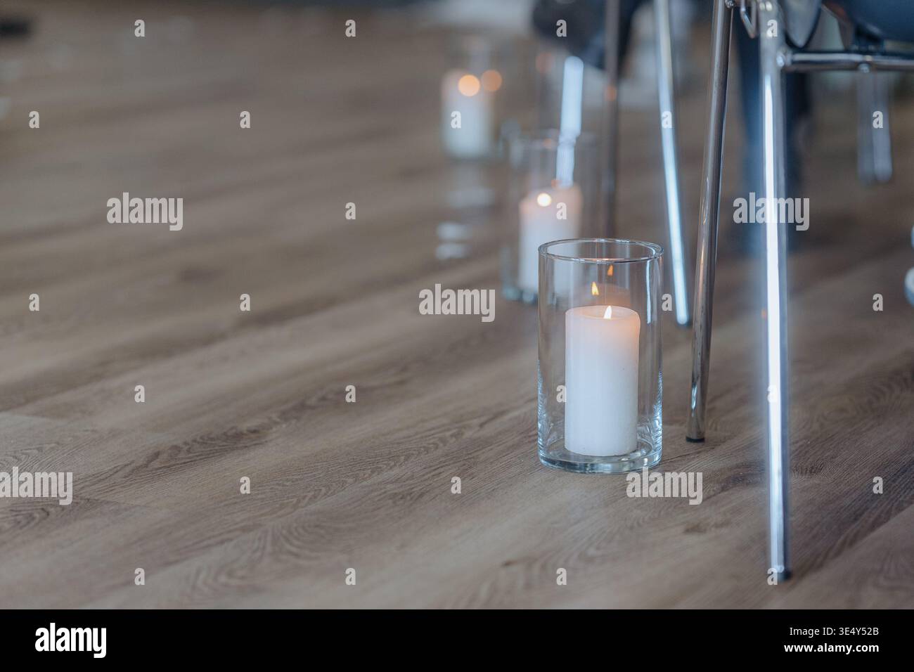 Bougies placées le long de l'allée créant une atmosphère romantique pour la cérémonie de mariage. Décoration élégante, éclairage tamisé, tons chaleureux. Banque D'Images