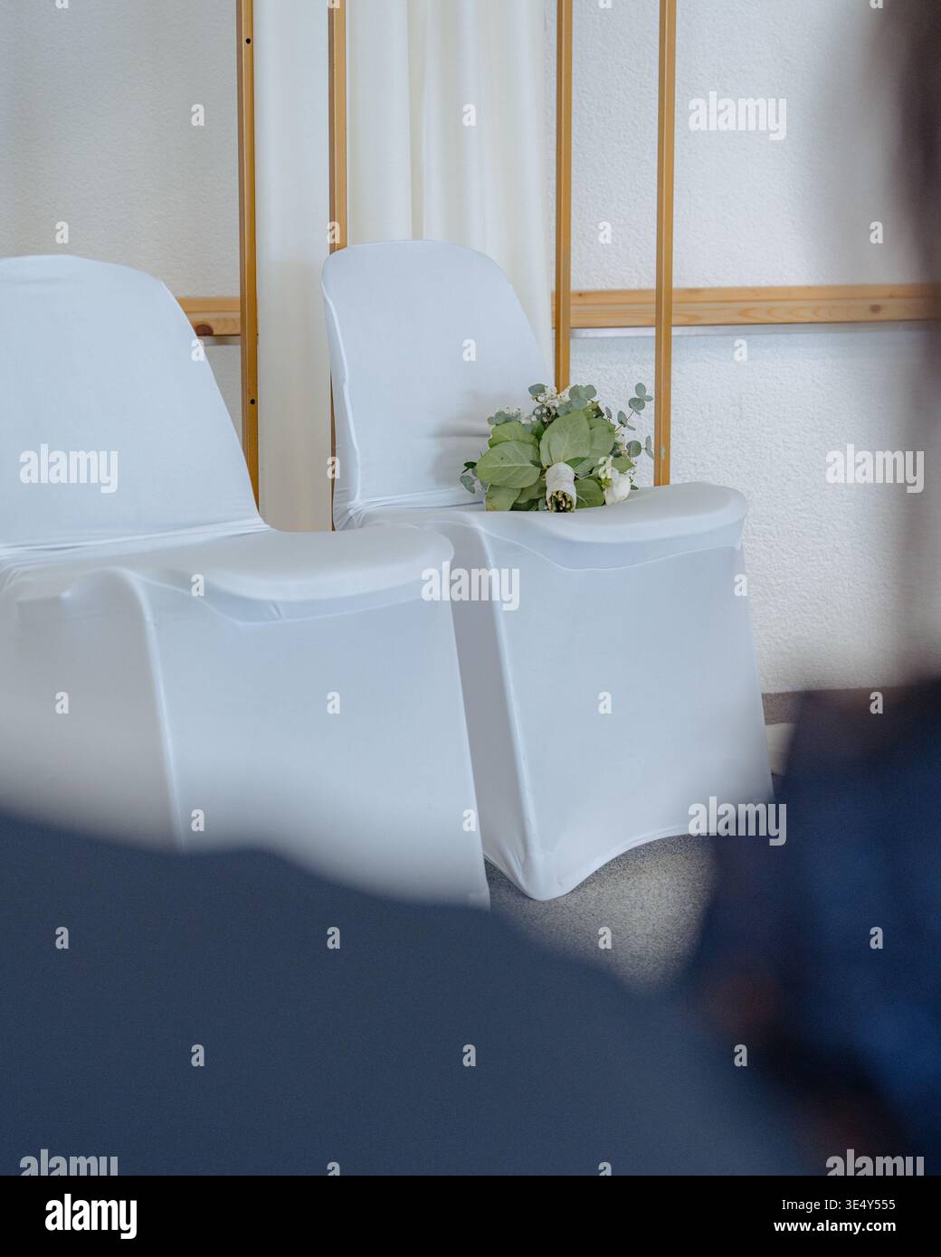 Configuration cérémonie de mariage avec chaises blanches et décor minimaliste. Intérieur propre et élégant pour événement, célébration ou occasion formelle. Banque D'Images
