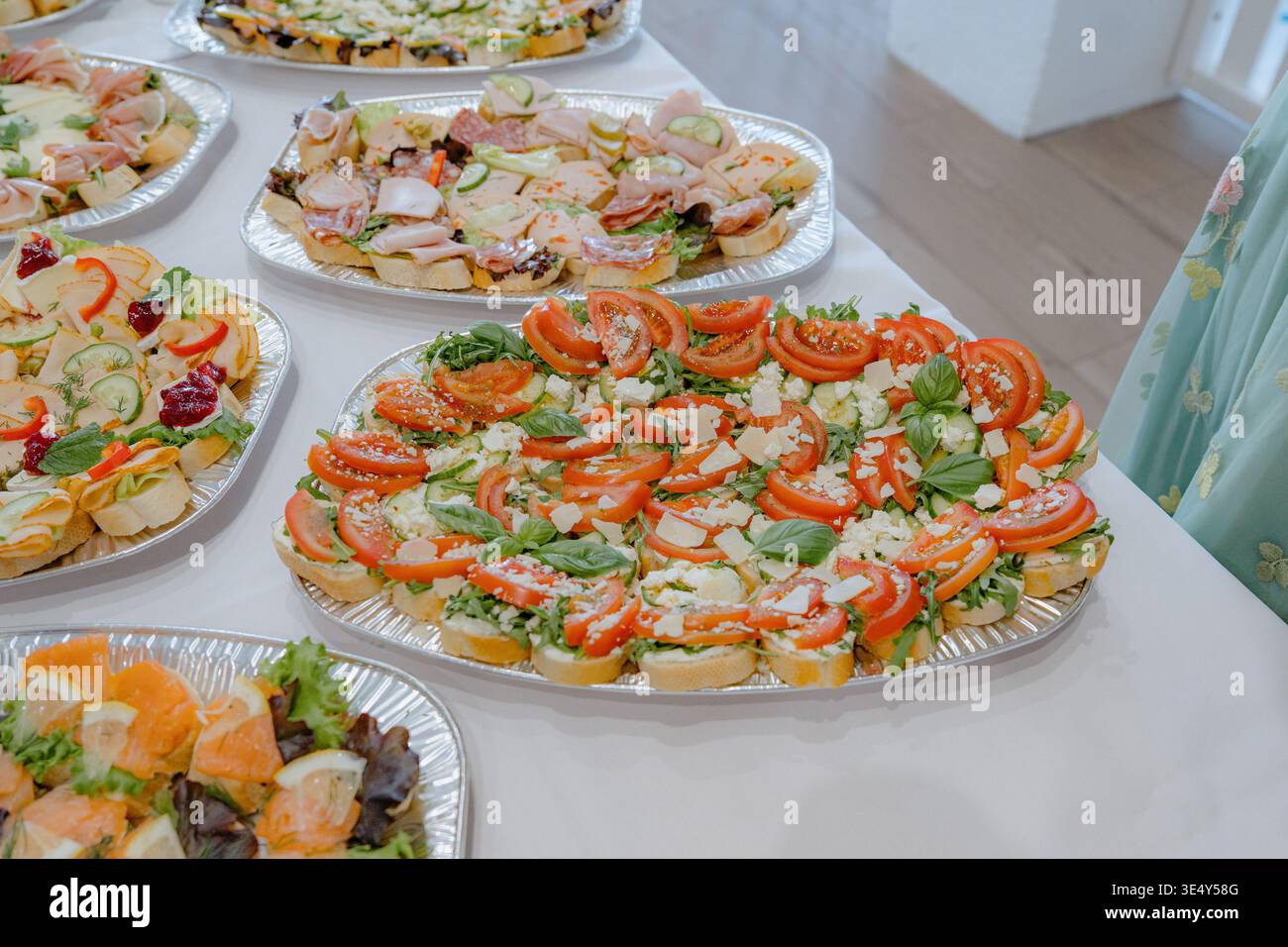 Canapés assortis avec tomates et légumes verts sur des plateaux de restauration. Amuse-gueules légers et frais pour buffet, fête ou événement d'entreprise. Propre et appétissant Banque D'Images