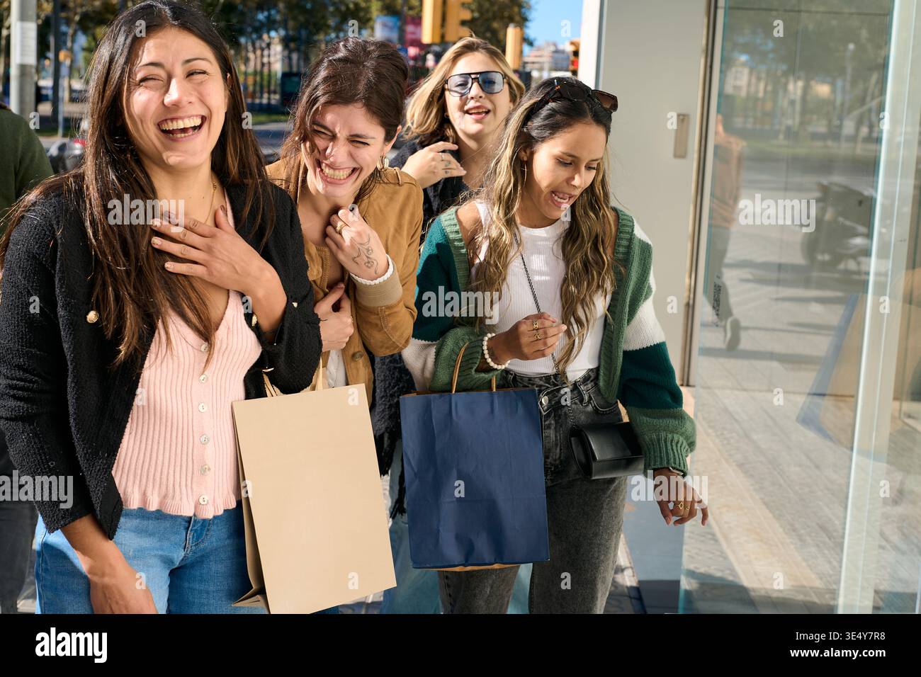 Groupe de femmes joyeuses riant profitant du shopping Banque D'Images