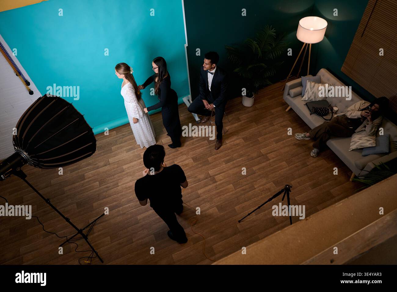 Équipe diversifiée préparant des modèles pour le photoshoot en studio Banque D'Images