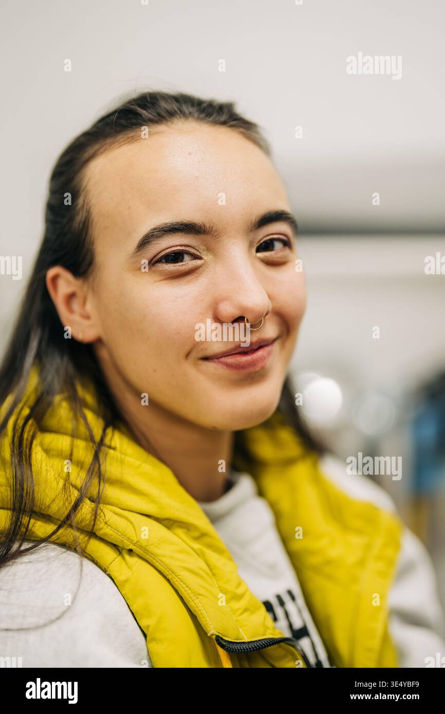 Femme portant un gilet jaune souriant avec un anneau de septum Banque D'Images