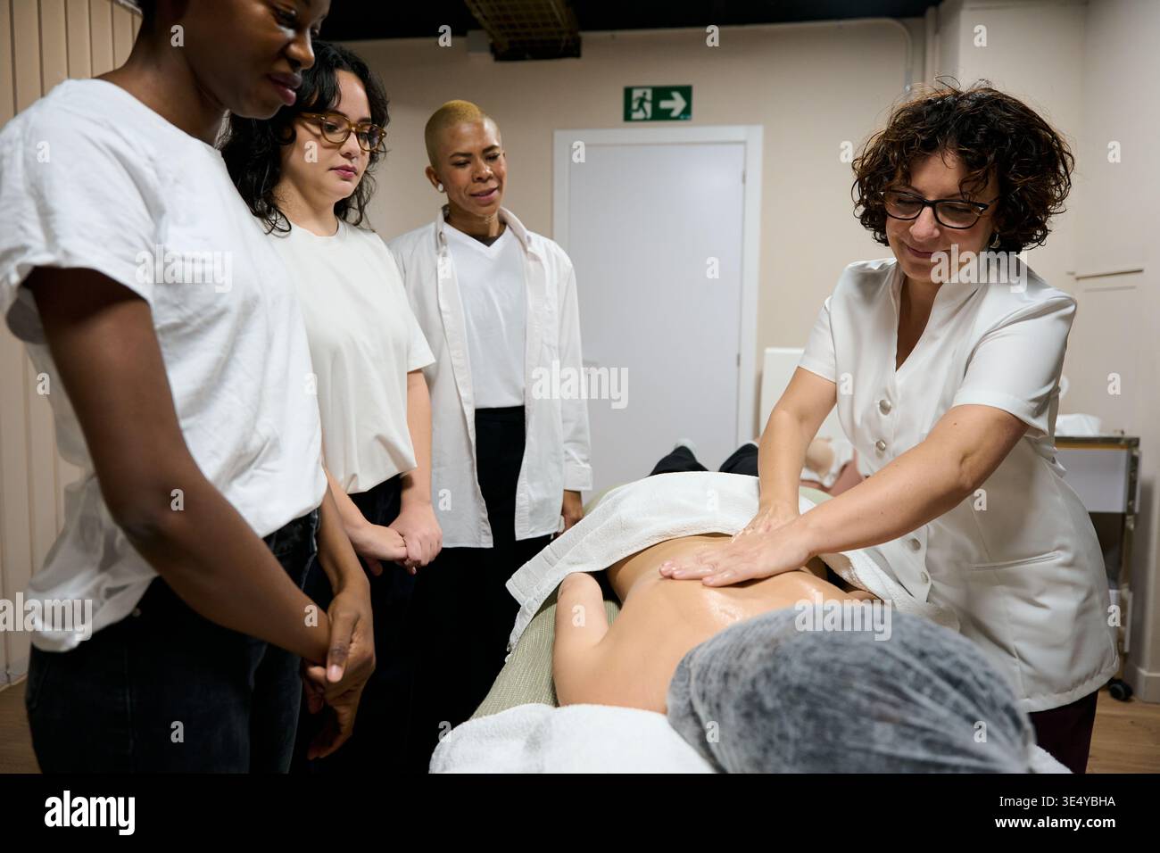 Enseignante démontrant les techniques de massage aux élèves Banque D'Images