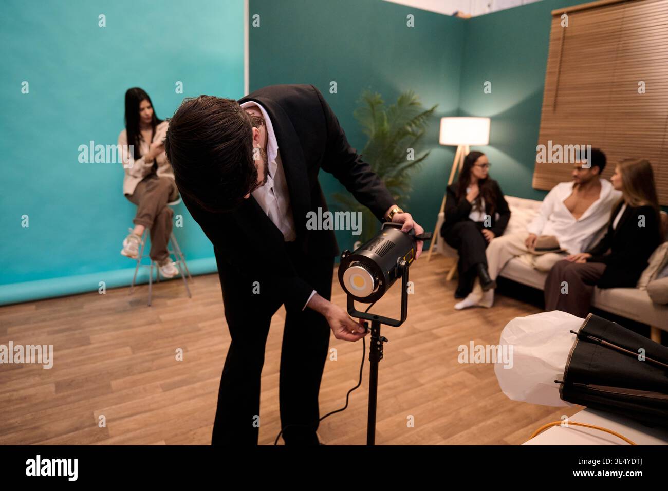 Photographe ajustant la lumière professionnelle du studio pour les prises de vue de mode Banque D'Images