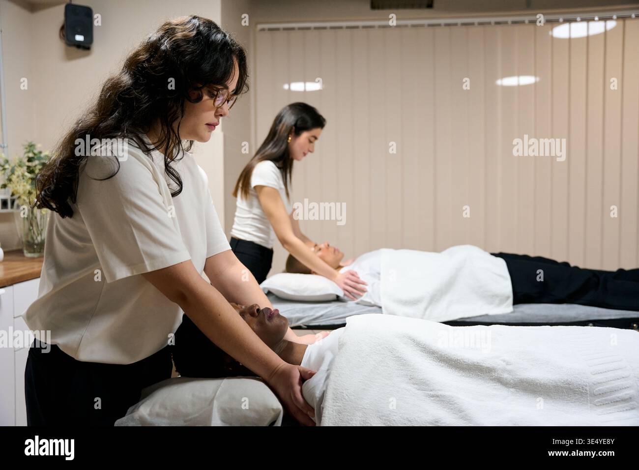 Masseurs féminins donnant massage du cou au spa Banque D'Images