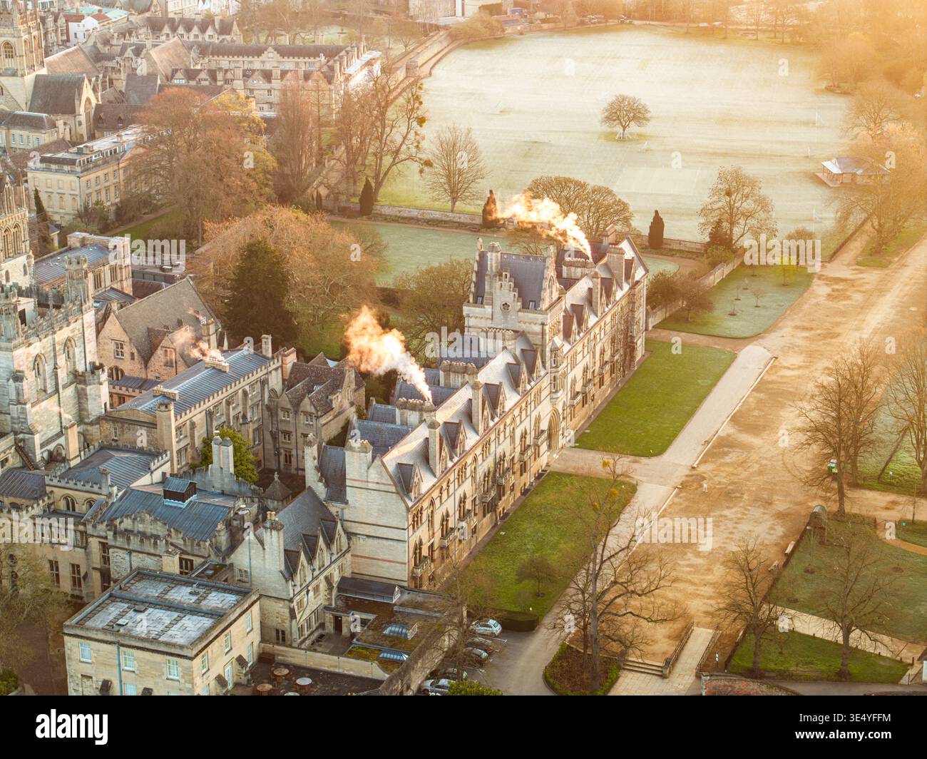 Vue aérienne de la grande architecture du Magdalen College se dresse majestueusement au milieu des pelouses soignées et de la paisible rivière Cherwell, une scène intemporelle baignée Banque D'Images