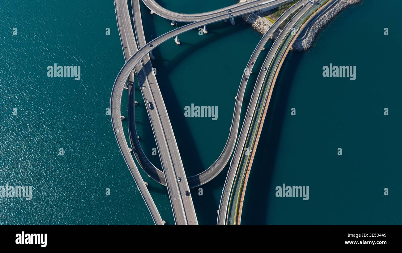 Vue aérienne de l'échangeur du pont Cross Bay Link avec des routes courbes au-dessus de l'eau bleue profonde dans les nouveaux Territoires, Hong Kong. Banque D'Images