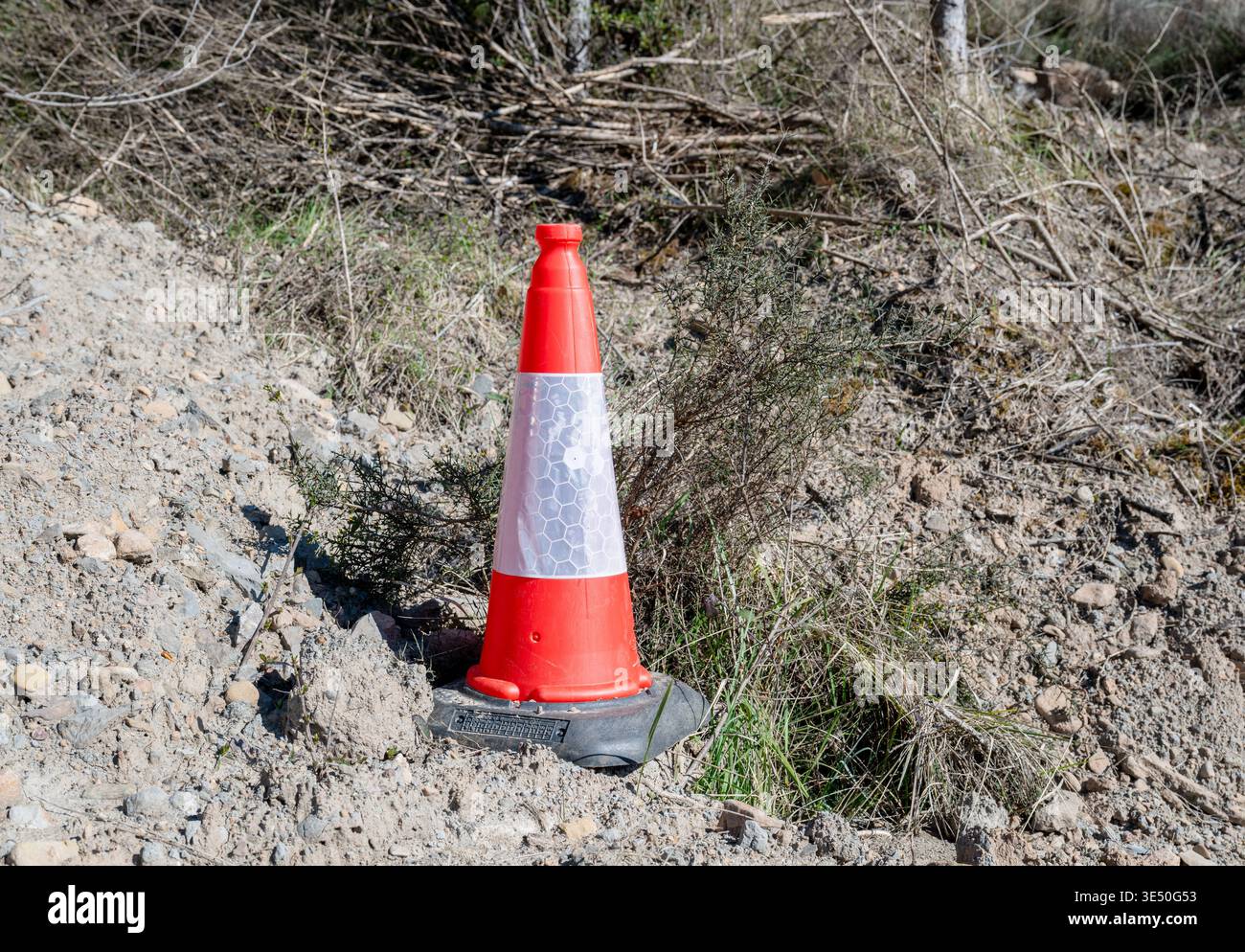 Cône de circulation orange vif sur l'équipement d'avertissement de sécurité de la zone de construction en bord de route dans un environnement extérieur Banque D'Images